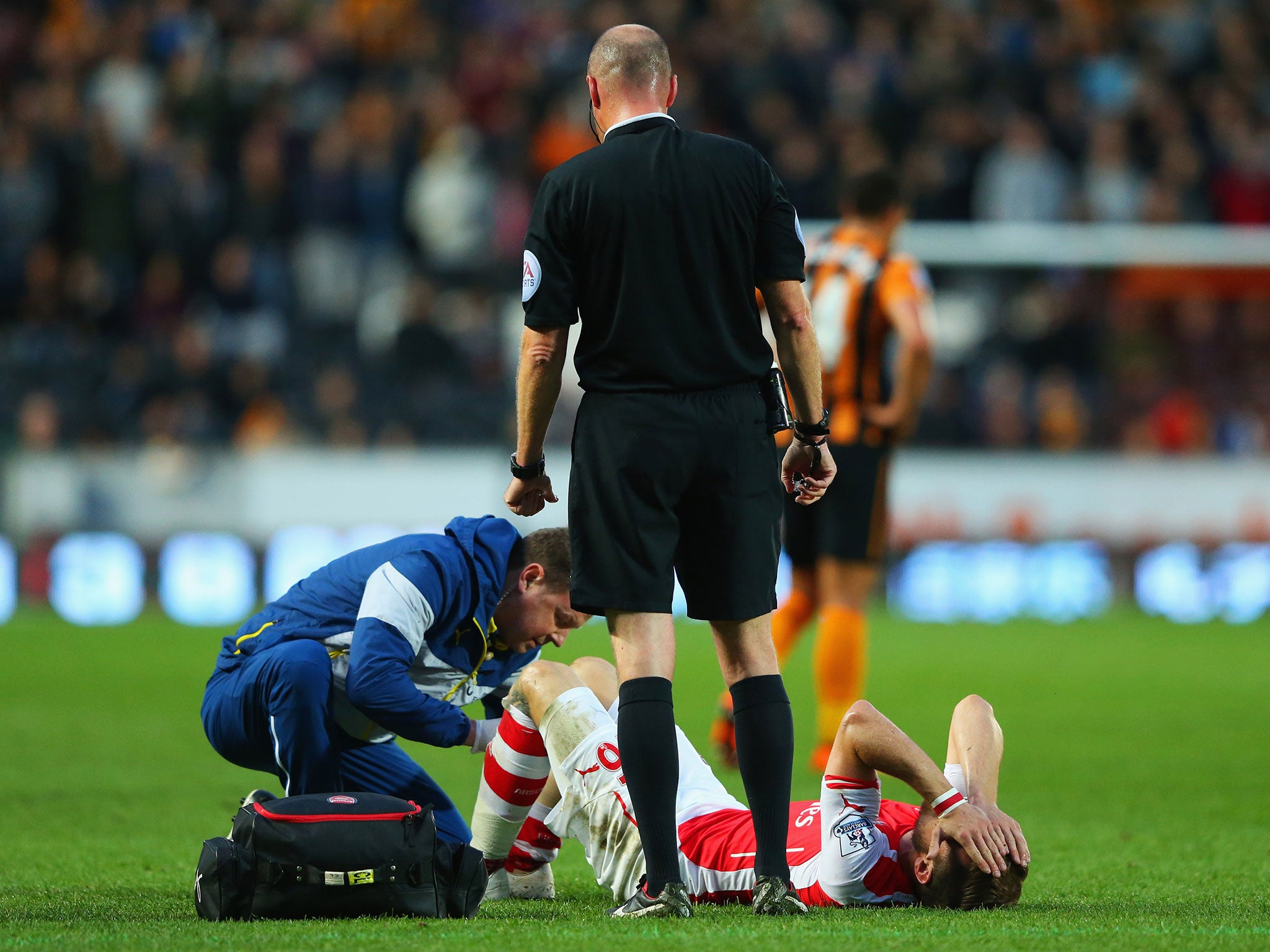 Aaron Ramsey receives treatment after being kicked on the leg