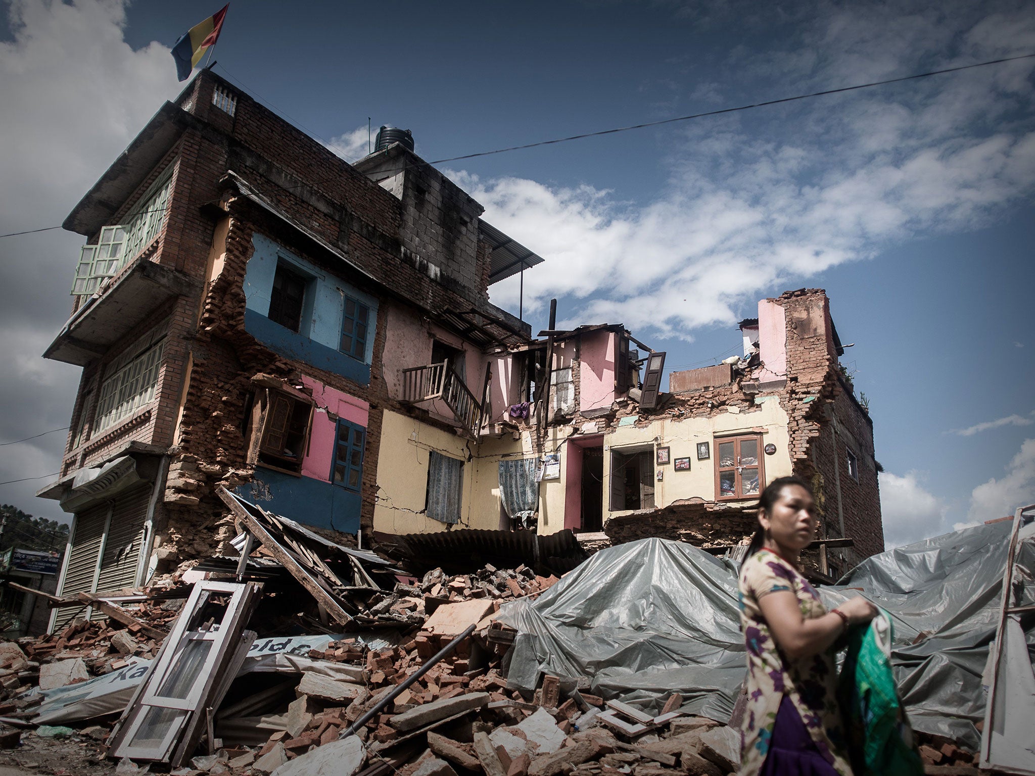 An earthquake survivor passes a destroyed house in Chautara, about 50 miles from Kathmandu in the central Sindhupalchok district, one of the worst-hit areas