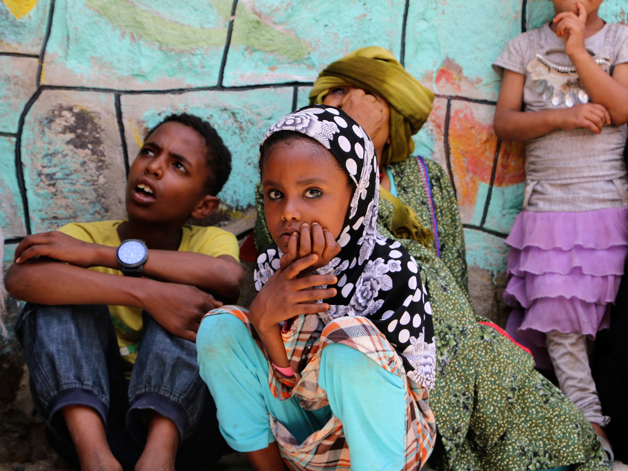 Displaced families who fled fighting in the southern city of Aden wait for relief supplies during a food distribution effort by Yemeni volunteers, in Taiz, Yemen