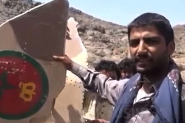 An image taken from the Huthi rebel television station Al-Masira shows Yemeni tribesmen celebrating around the wreckage of a plane bearing a Moroccan flag, in the the Wadi Nushur area in the north Yemen's province of Saada