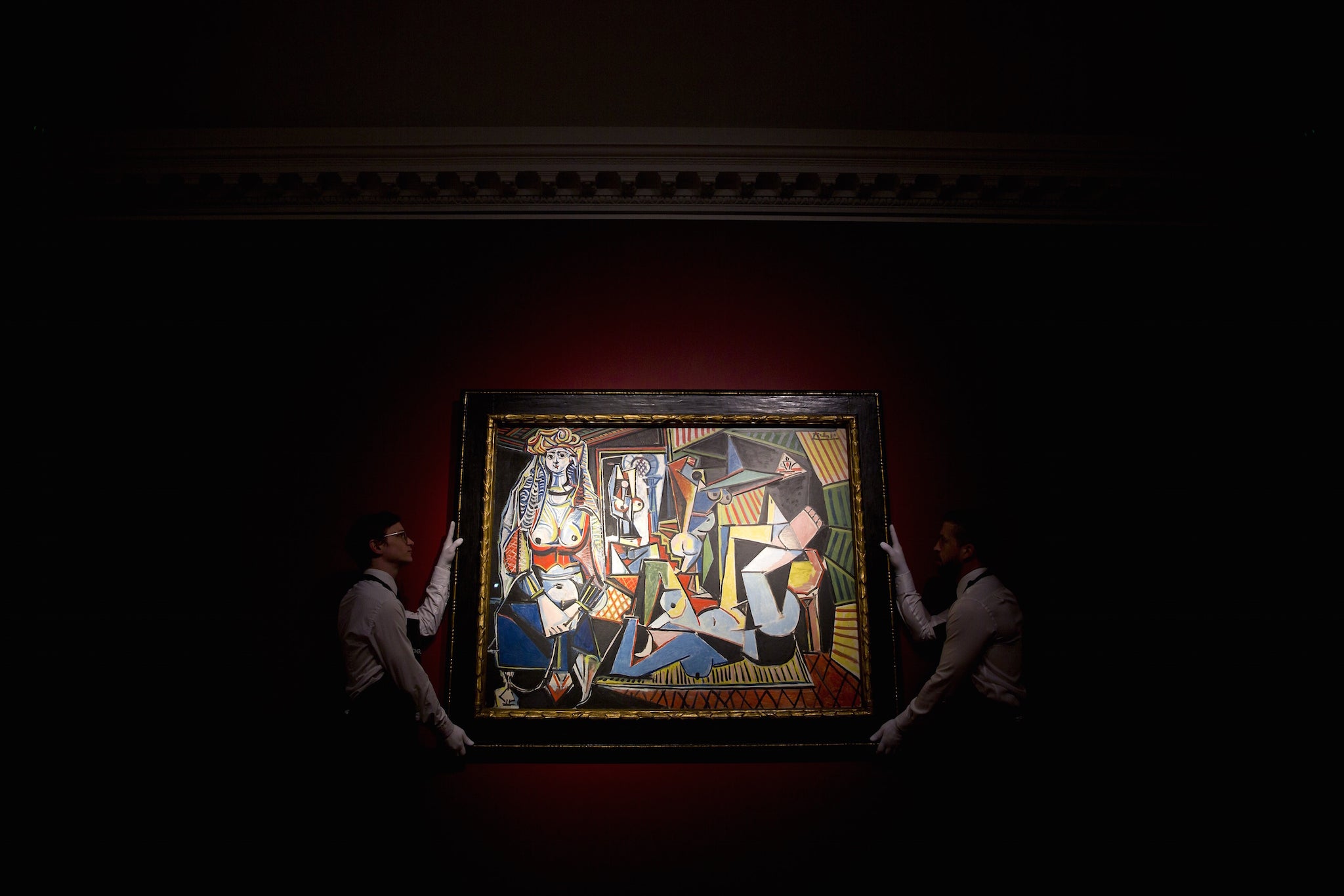 Christie's staff hold up Picasso's Les femmes d’Alger (version O) ahead of the auction
