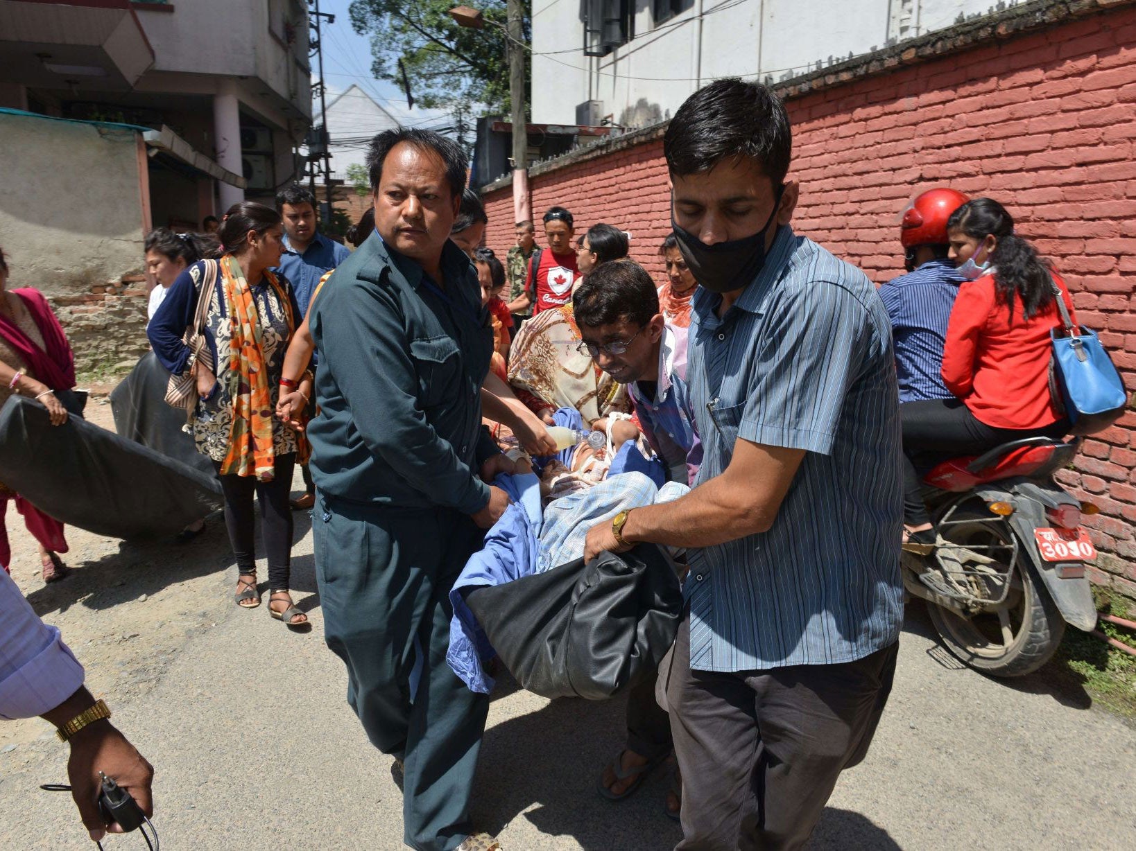 Nepalese patients are carried out of a hospital building as a 7.3 magnitude earthquake hits the country, in Kathmandu on Tuesday