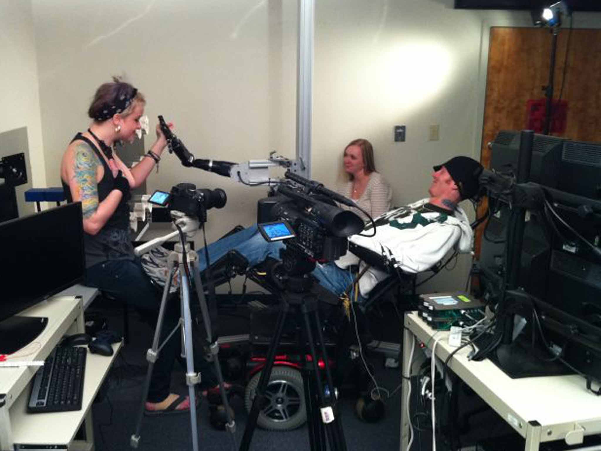 Study participant Tim Hemmes reaching out to his girlfriend, Katie Schaffer, using a brain-controlled prosthetic arm