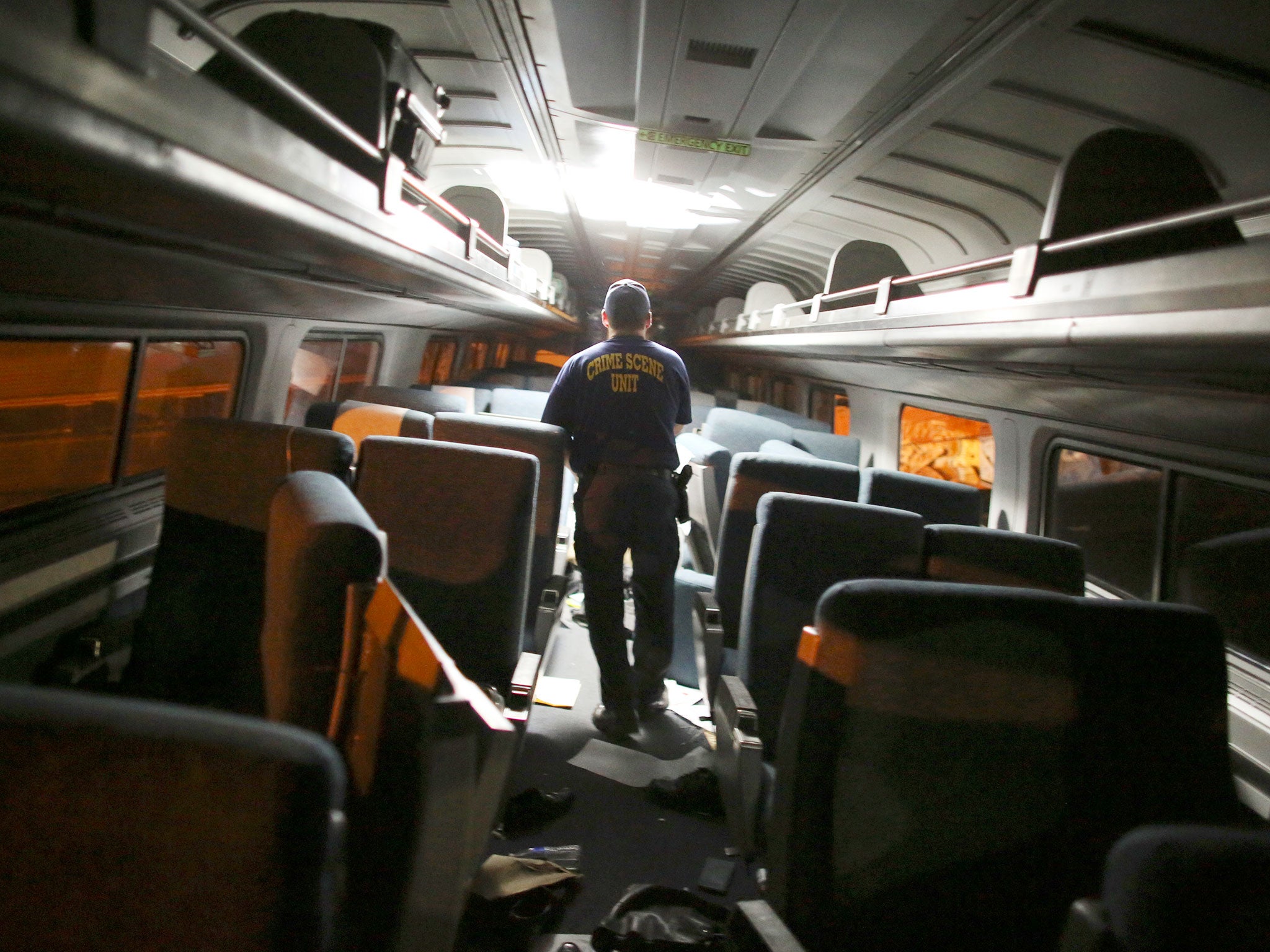 A crime scene investigator looks inside a train car