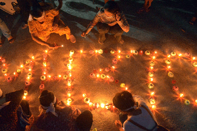 Cambodian residents of a community light candles as they pray for the missing Malaysia Airlines flight MH370 at their village in Phnom Penh on March 17, 2014