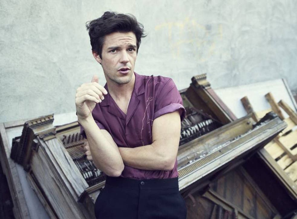 Brandon Flowers wondering why there is a broken piano behind him
