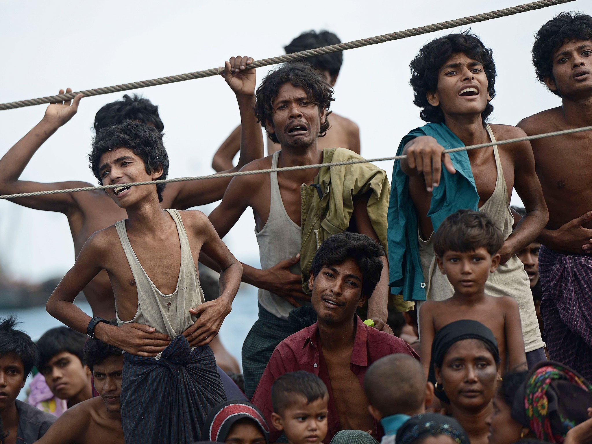 Rohingya migrants stand and sit on a boat drifting in Thai waters off the southern island of Koh Lipe in the Andaman sea