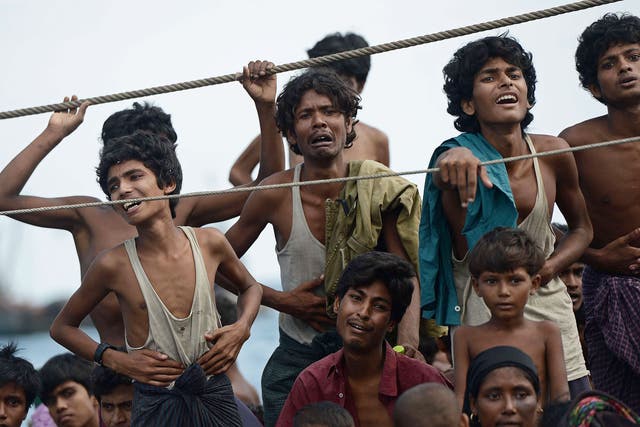 Rohingya migrants stand and sit on a boat drifting in Thai waters off the southern island of Koh Lipe in the Andaman sea  