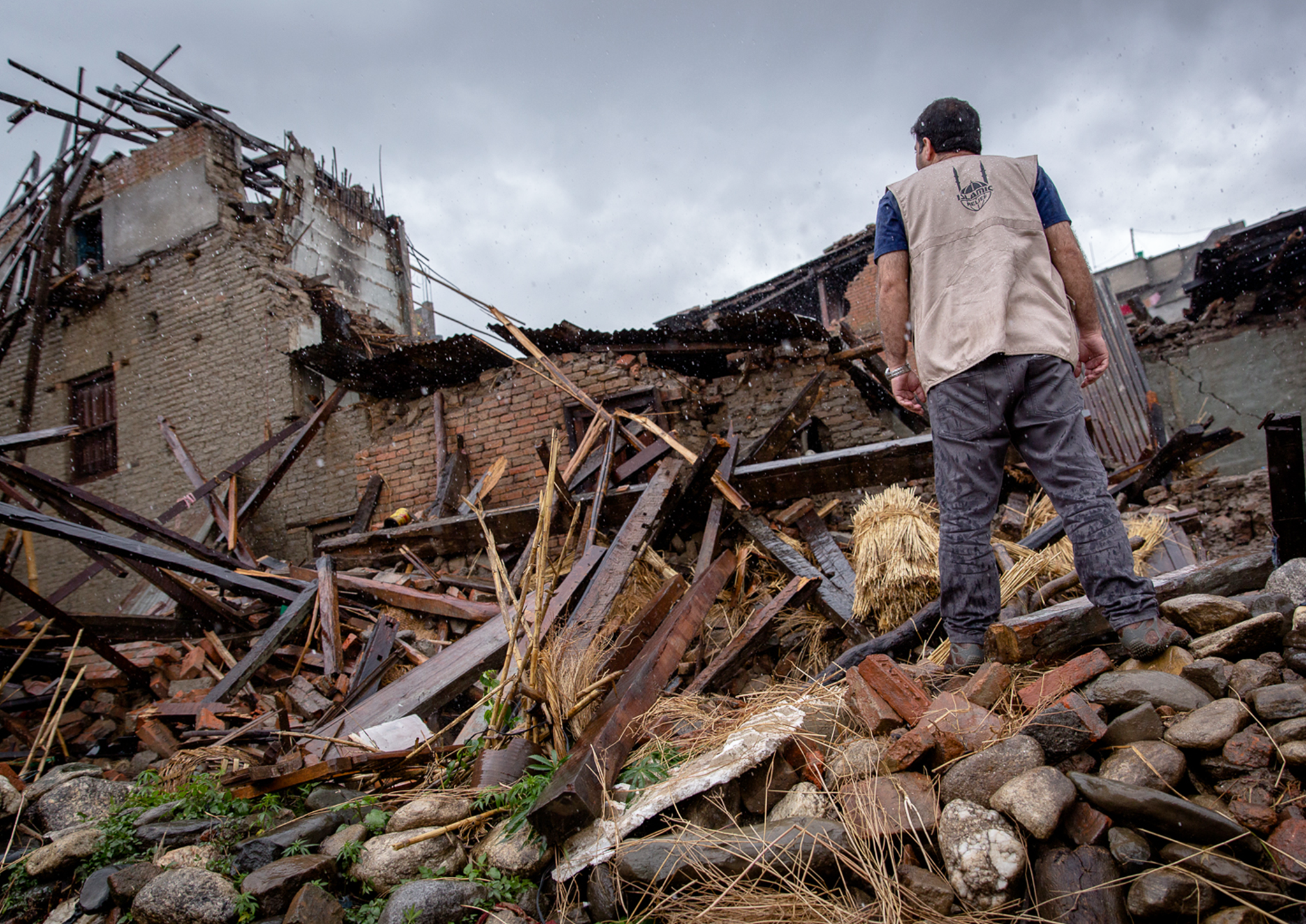 A rescue worker searches among the rubble of one of Nepal's many collapsed buildings