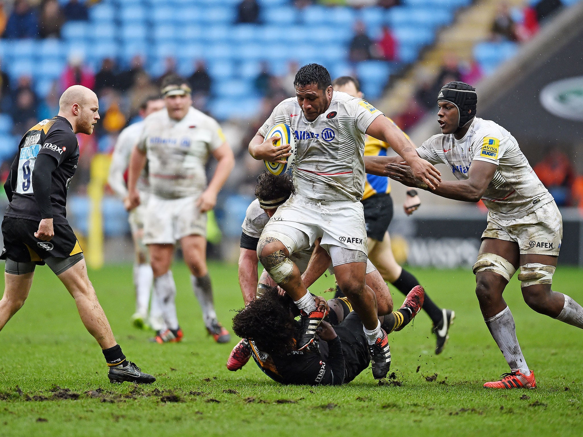 Mako Vunipola, center, being tackled while in action for Saracens