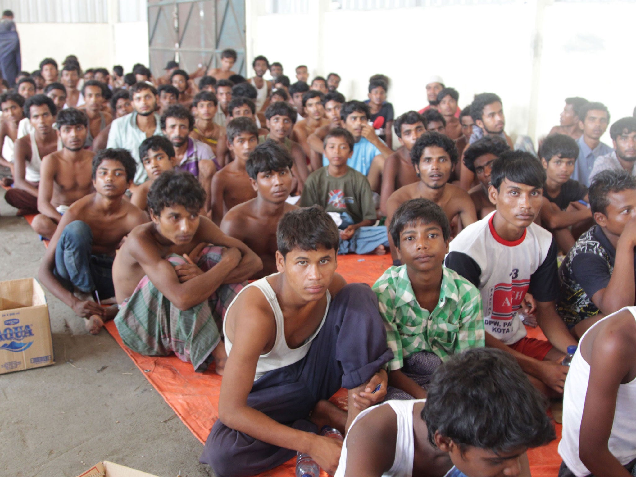 The group of rescued migrants mostly Rohingya from Myanmar and Bangladesh gather on arrival at the new confinement area in the fishing town of Kuala Langsa