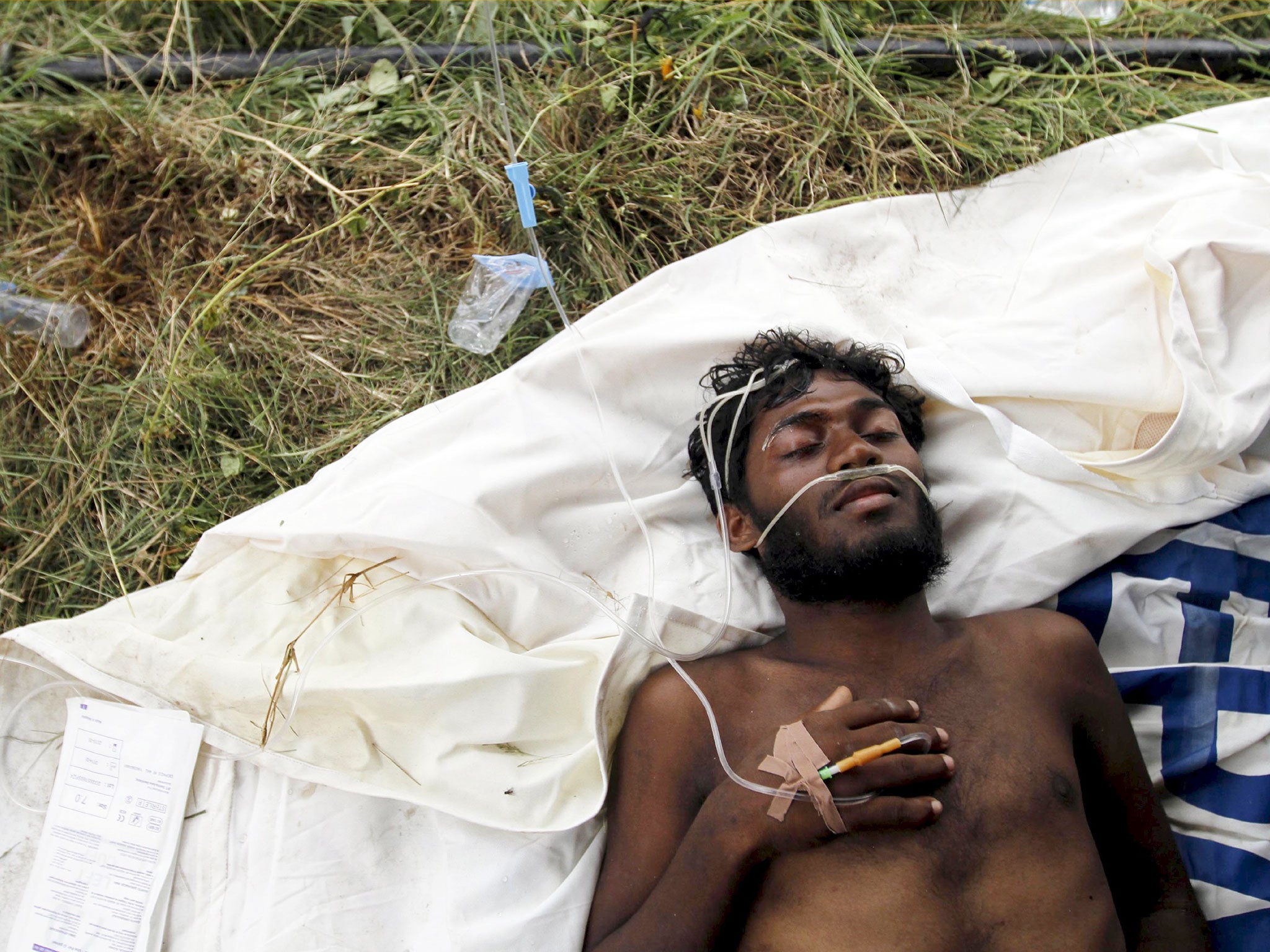 A migrant who arrived by boat, part of a group of Rohingya and Bangladeshis, receives medical assistance at an aid station in Kuala Langsa in Indonesia's Aceh Province
