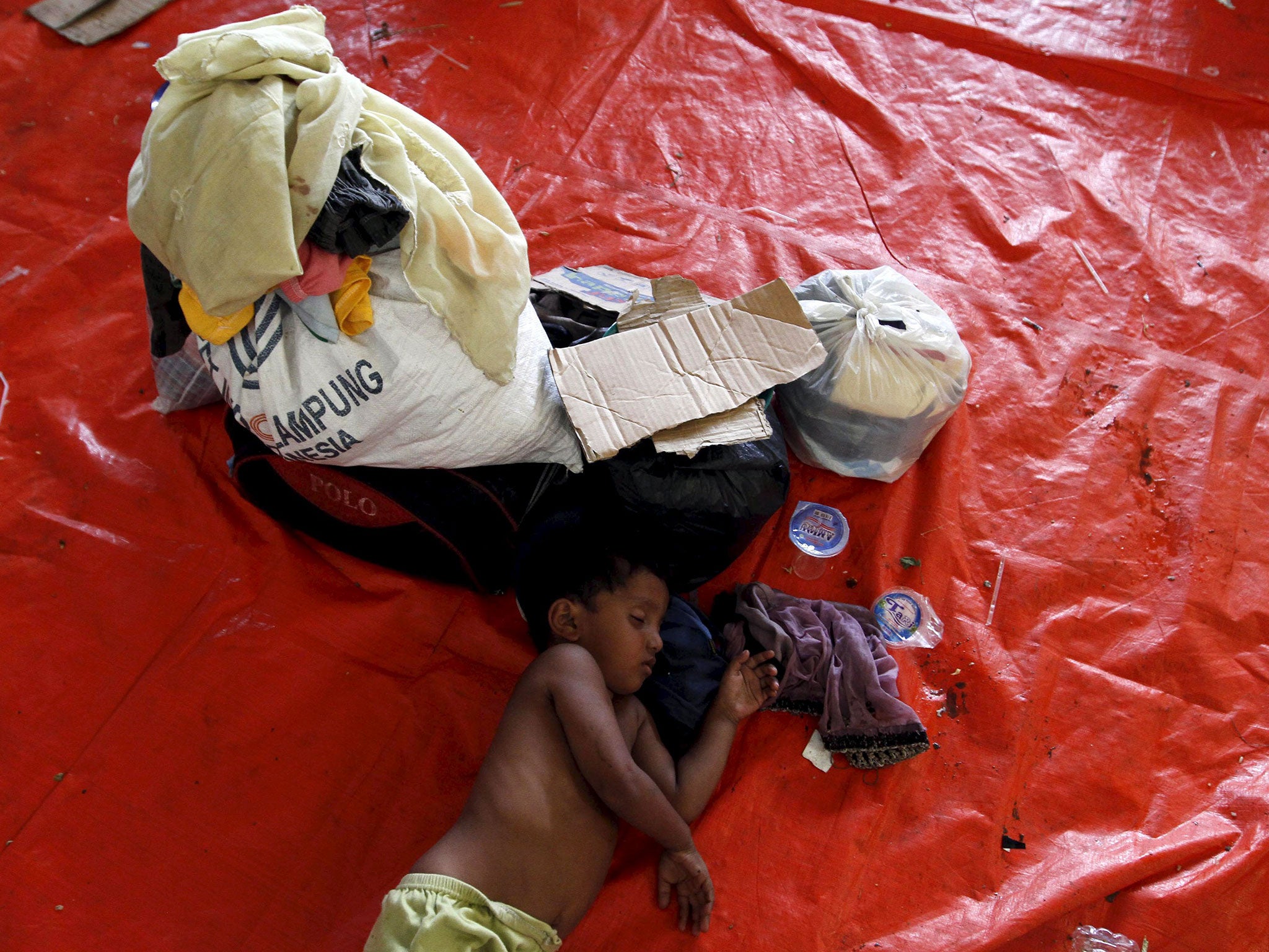 A child who arrived in Indonesia by boat with othermigrants, sleeps inside a temporary shelter at Kuala Langsa in Indonesia's Aceh Province