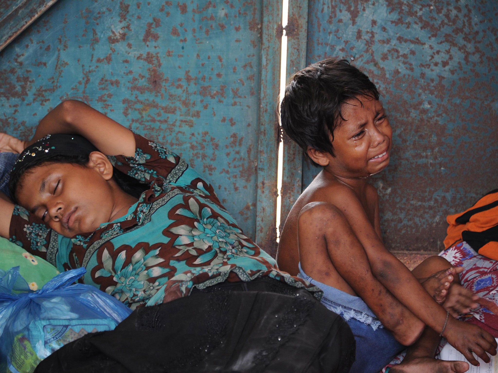 A young boy and his mother rest in a shelter