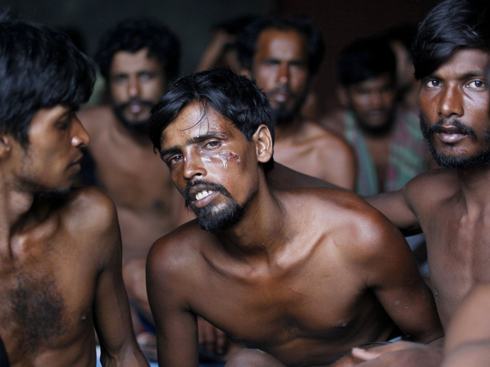 Bangladeshi migrants sit inside a temporary shelter at Kuala Langsa Port in Langsa