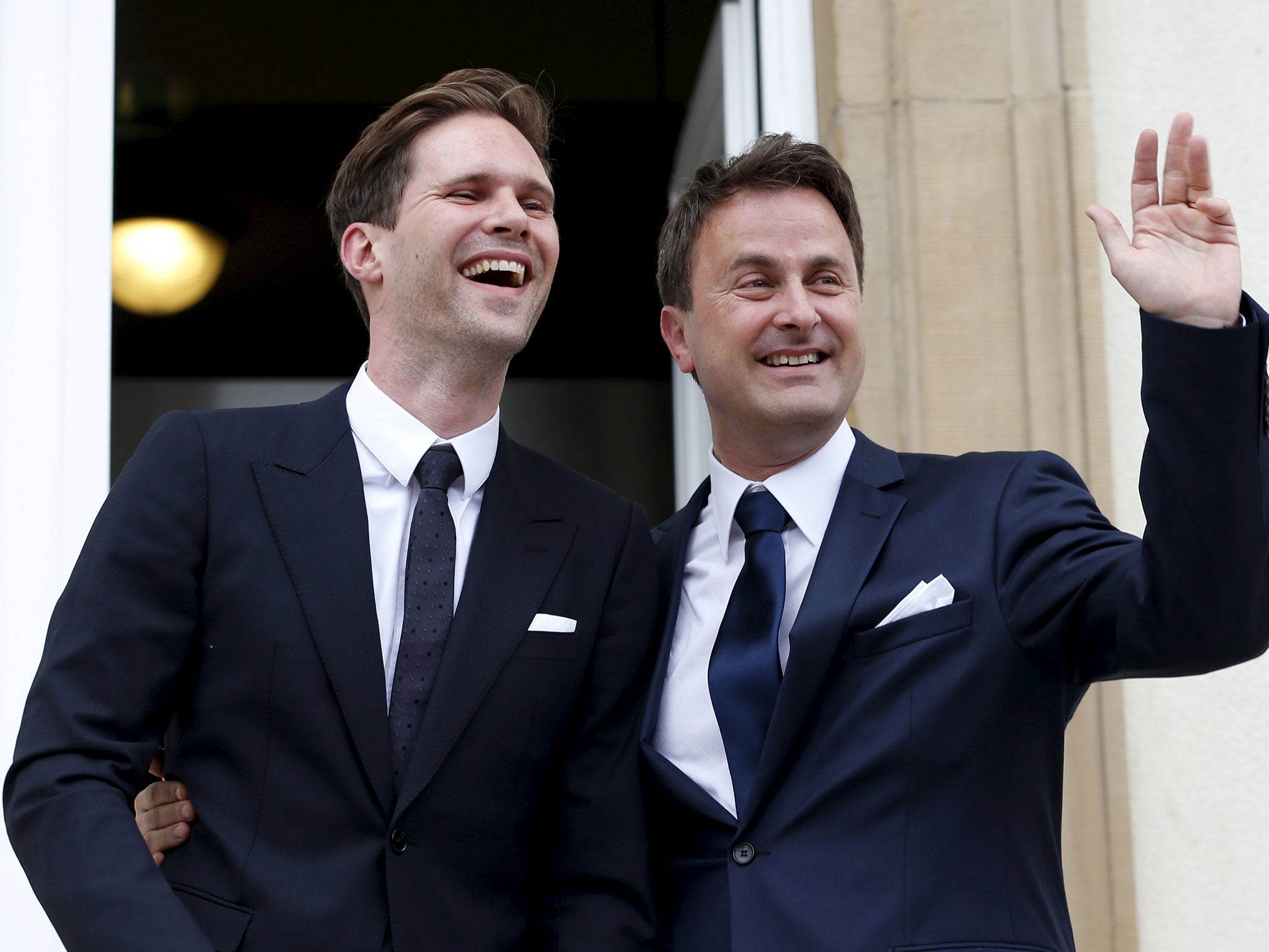 Luxembourg's Prime Minister Xavier Bettel waves as he poses with his partner Gauthier Destenay (L), after their wedding ceremony at Luxembourg's city hall, May 15, 2015.