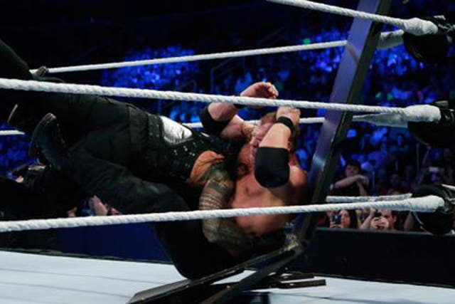 Roman Reigns spears Kane through a table