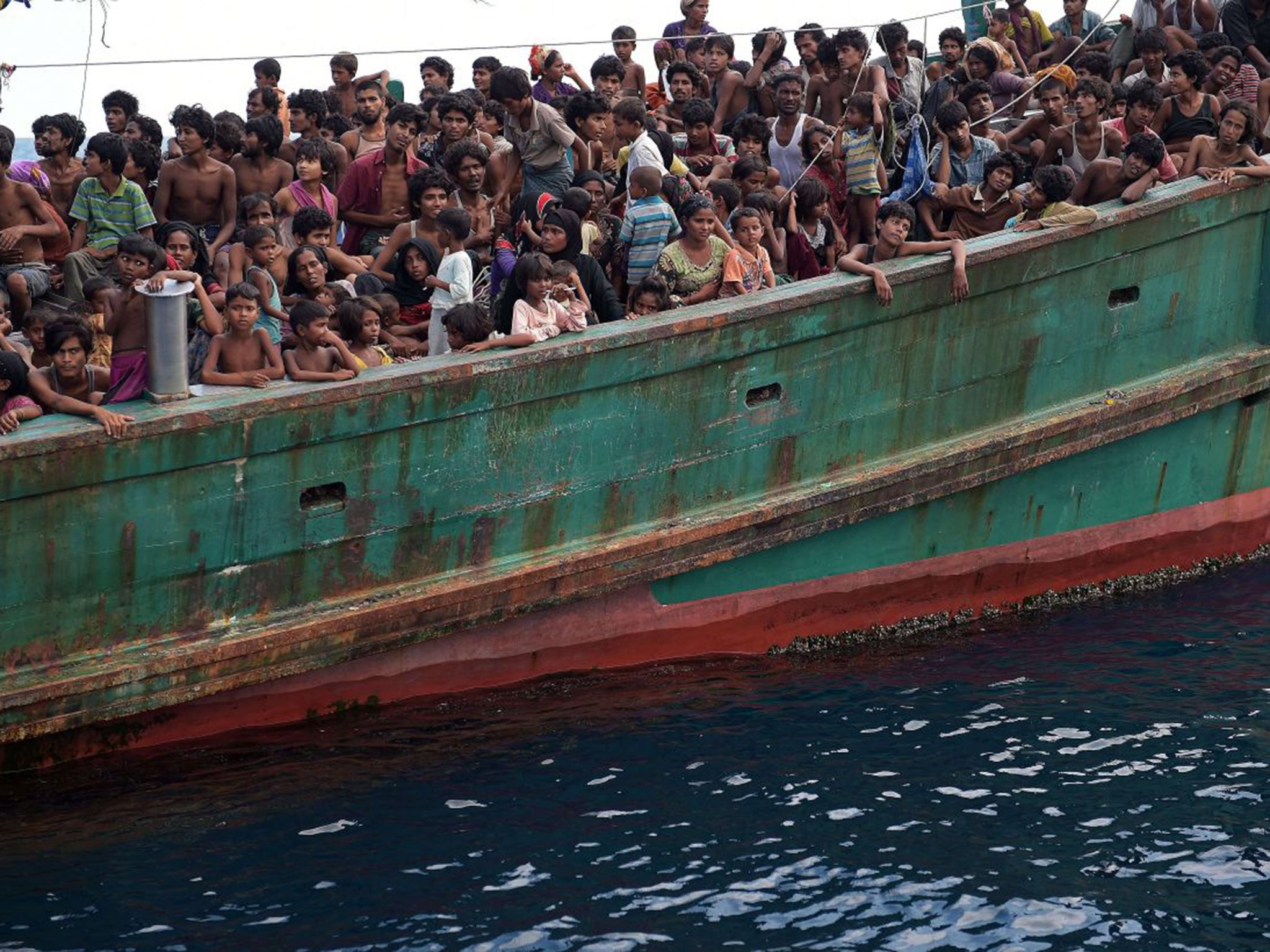 Boats bearing an estimated 8,000 more people continue to wallow in the Andaman Sea, refused permission to land by Thailand, Indonesia and Malaysia