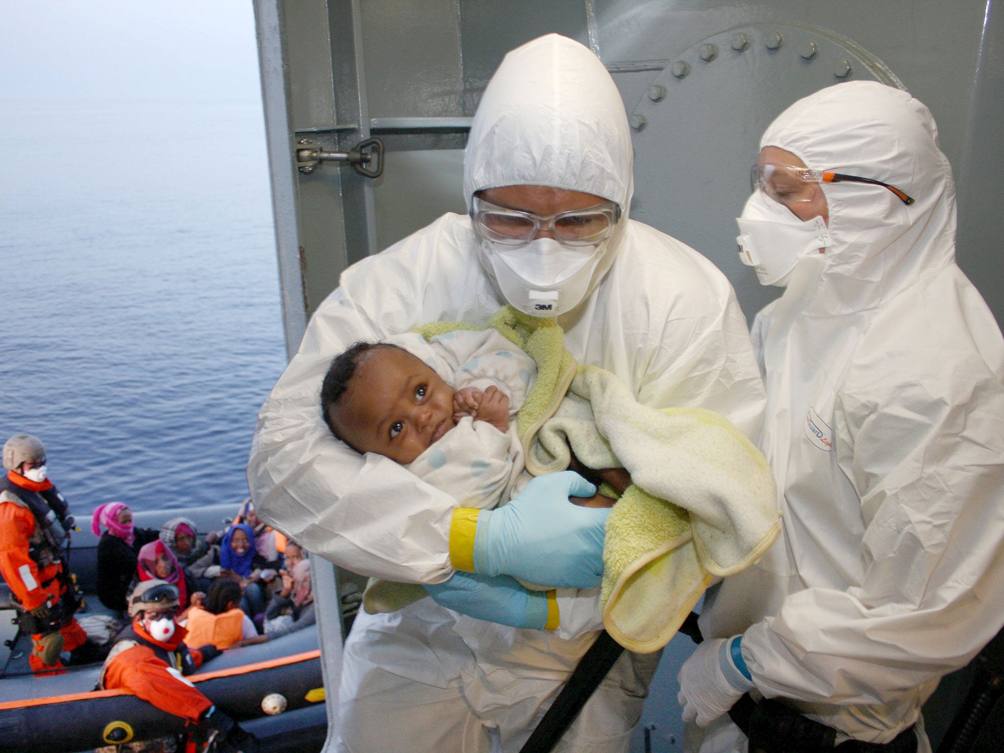 Rescuers treat a migrant baby on the frigate ‘Hessen’, off the coast of Libya