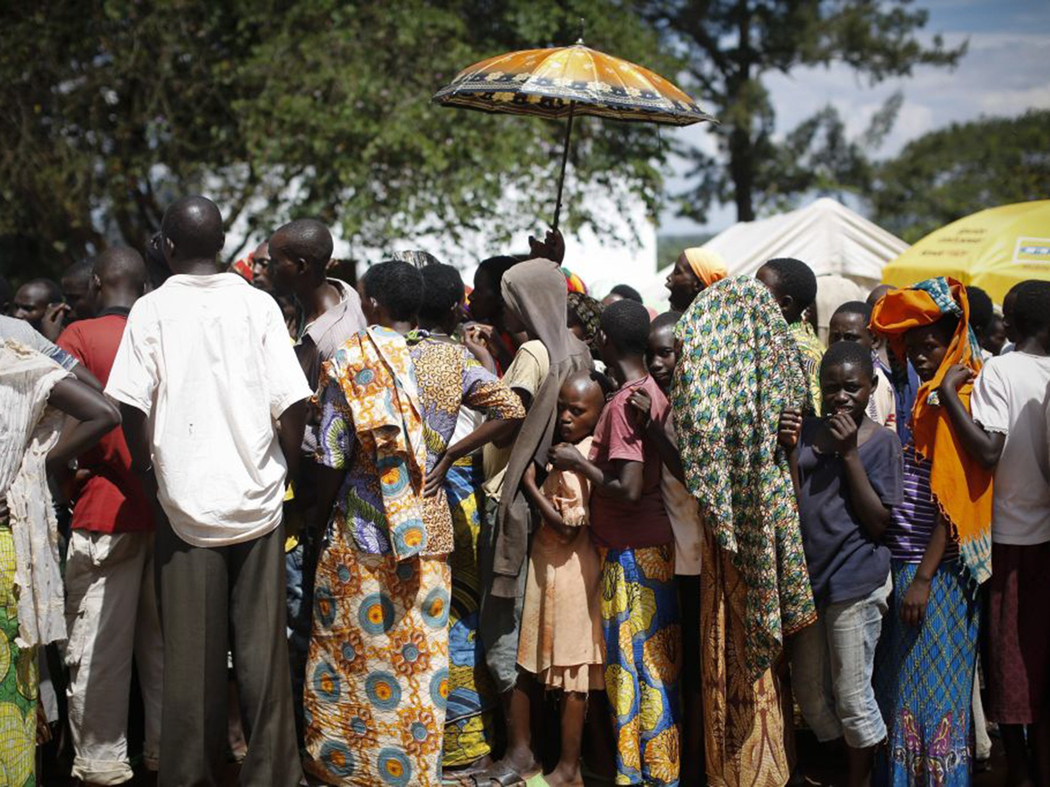 Burundian refugees queue to receive handout clothes in a refugee camp in Gashora, south of the capital Kigali