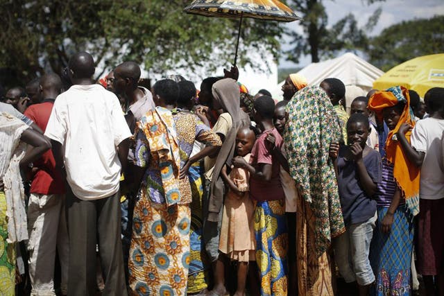 Burundian refugees queue to receive handout clothes in a refugee camp in Gashora,  south of the capital Kigali