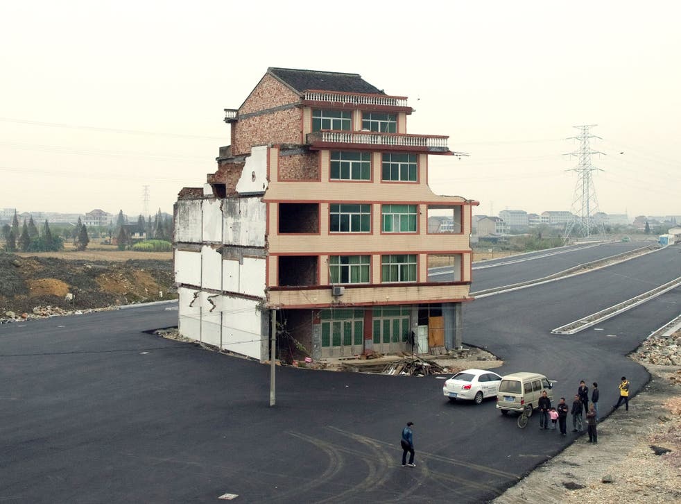 A half-demolished apartment building standing in the middle of a newly-built road thanks to a Chinese couple that refused to move in Wenling, in eastern China's Zhejiang province. Luo Baogen, 67, and his 65-year-old wife have waged a four-year battle to r