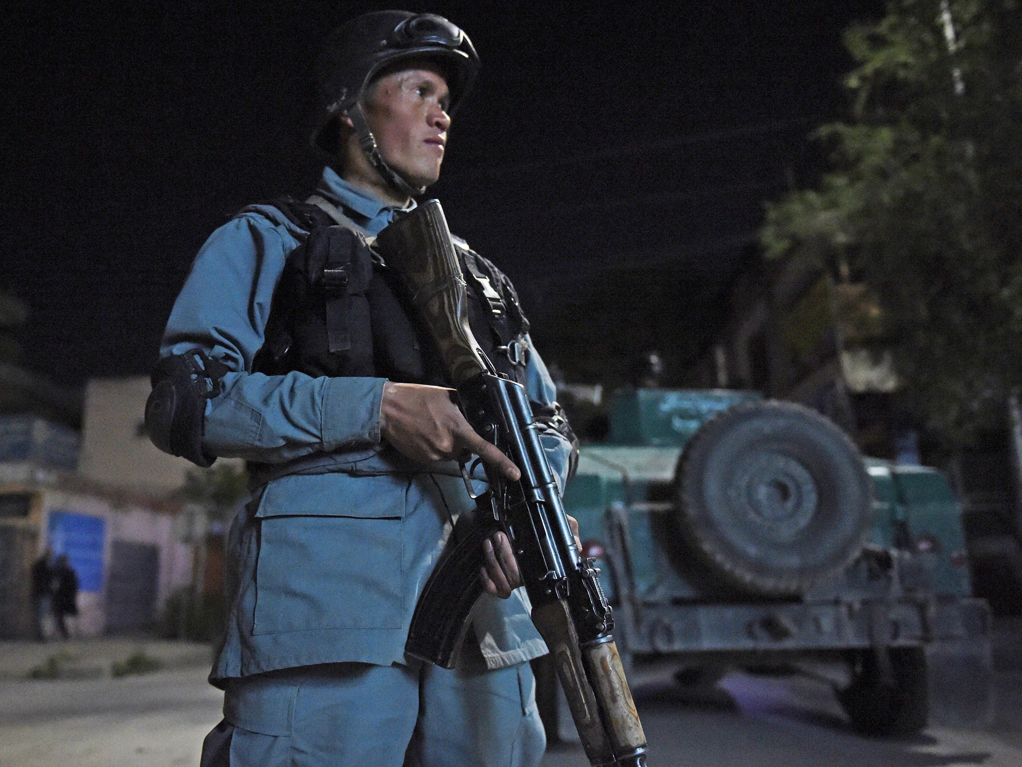 An Afghan policeman stands guard near the Park Place guesthouse in Kabul