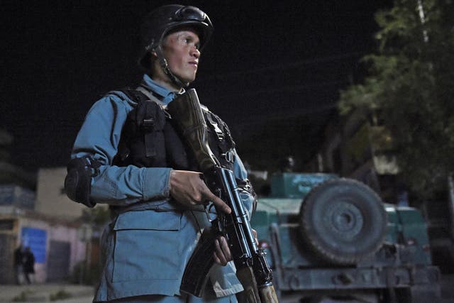 An Afghan policeman stands guard near the Park Place guesthouse in Kabul
