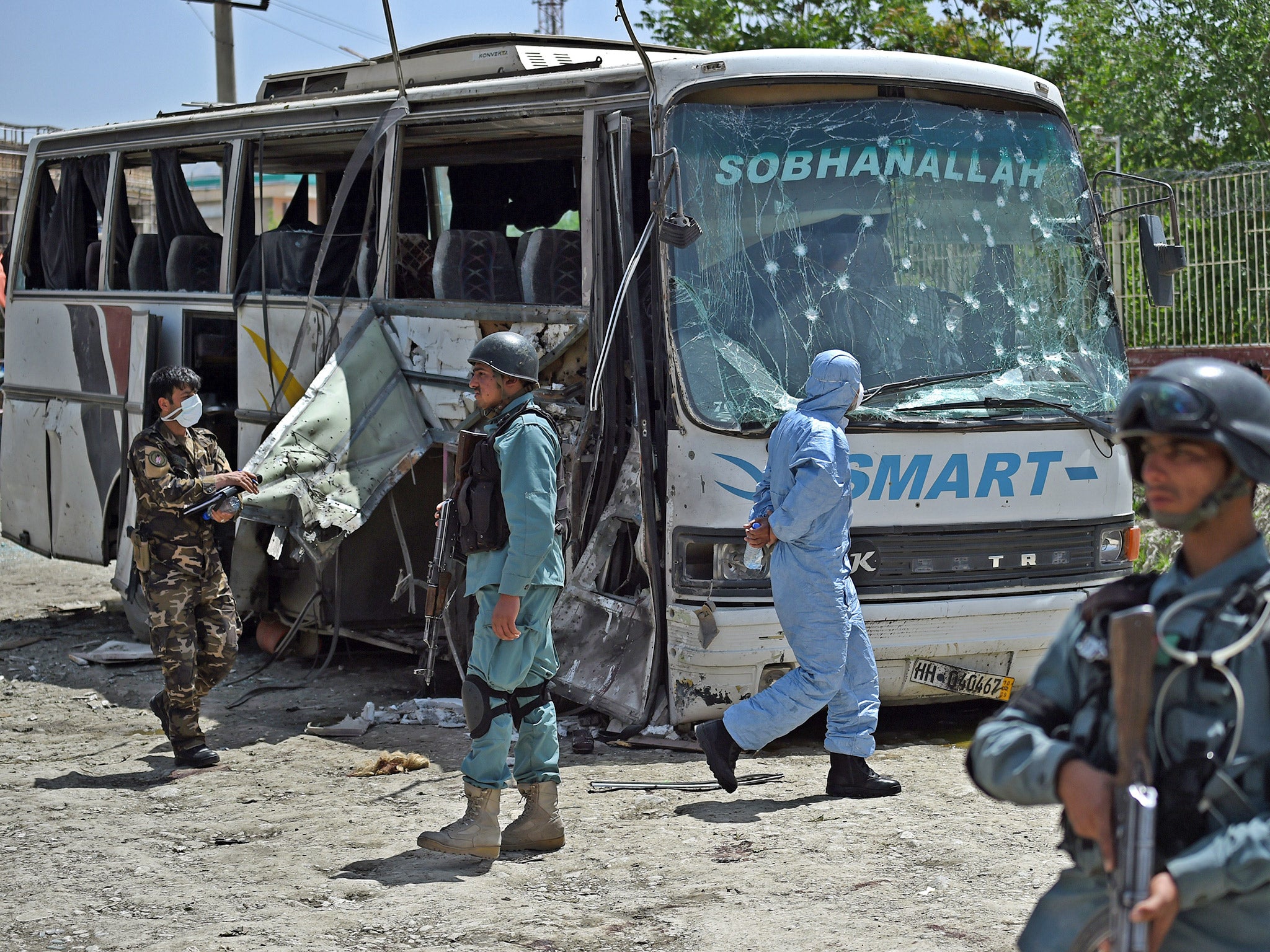 Afghan police and security personnel inspect the scene of a suicide attack on a bus in Kabul earlier this month (Getty)