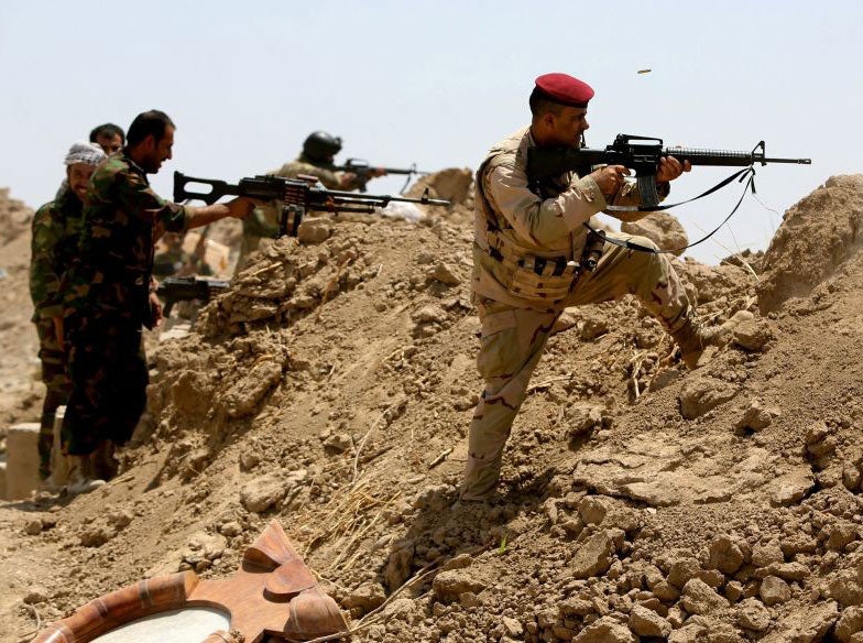 Iraqi soldiers and Iran-backed Shia hold a post as they fire towards Isis positions in the Garma district of Anbar province on 19 May