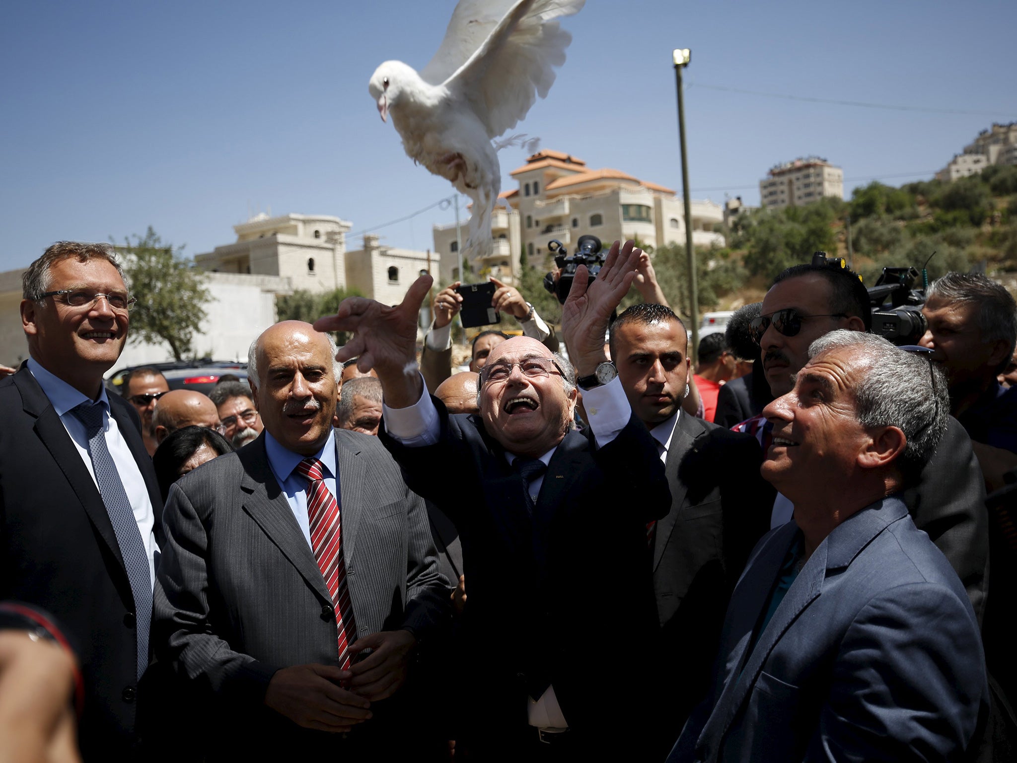 The Fifa president, Sepp Blatter, who says he is on a ‘peace mission’, releases a dove during his visit to Dura al-Qar’ village in the West Bank city of Ramallah