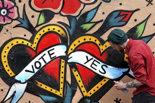 A graffiti artist finishes a Yes campaign piece in central Dublin