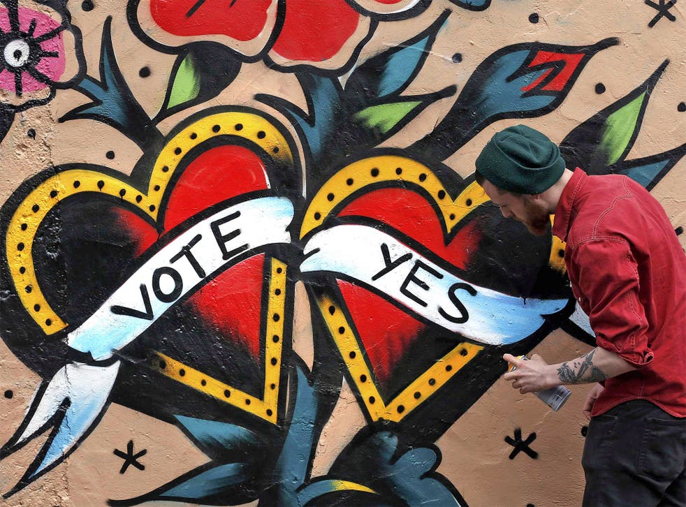 A graffiti artist finishes a Yes campaign piece in central Dublin