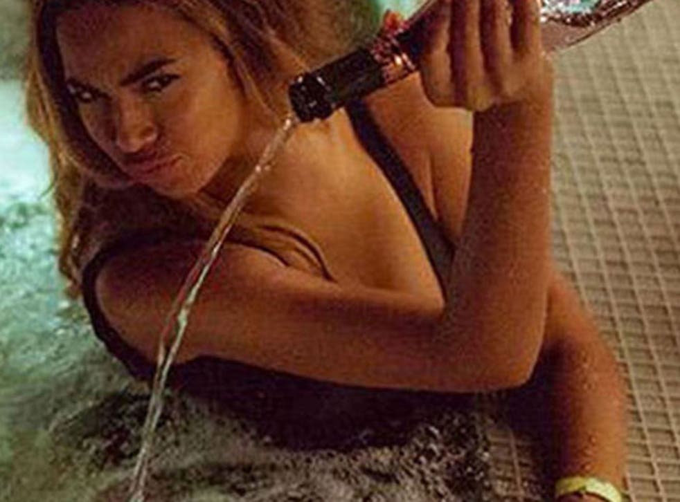 Beyonce pours champagne into a hot tub in the 'Feeling Myself' music video