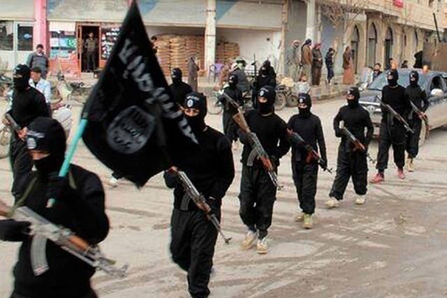 Masked Isis fighters march through the Syrian city of Raqqa