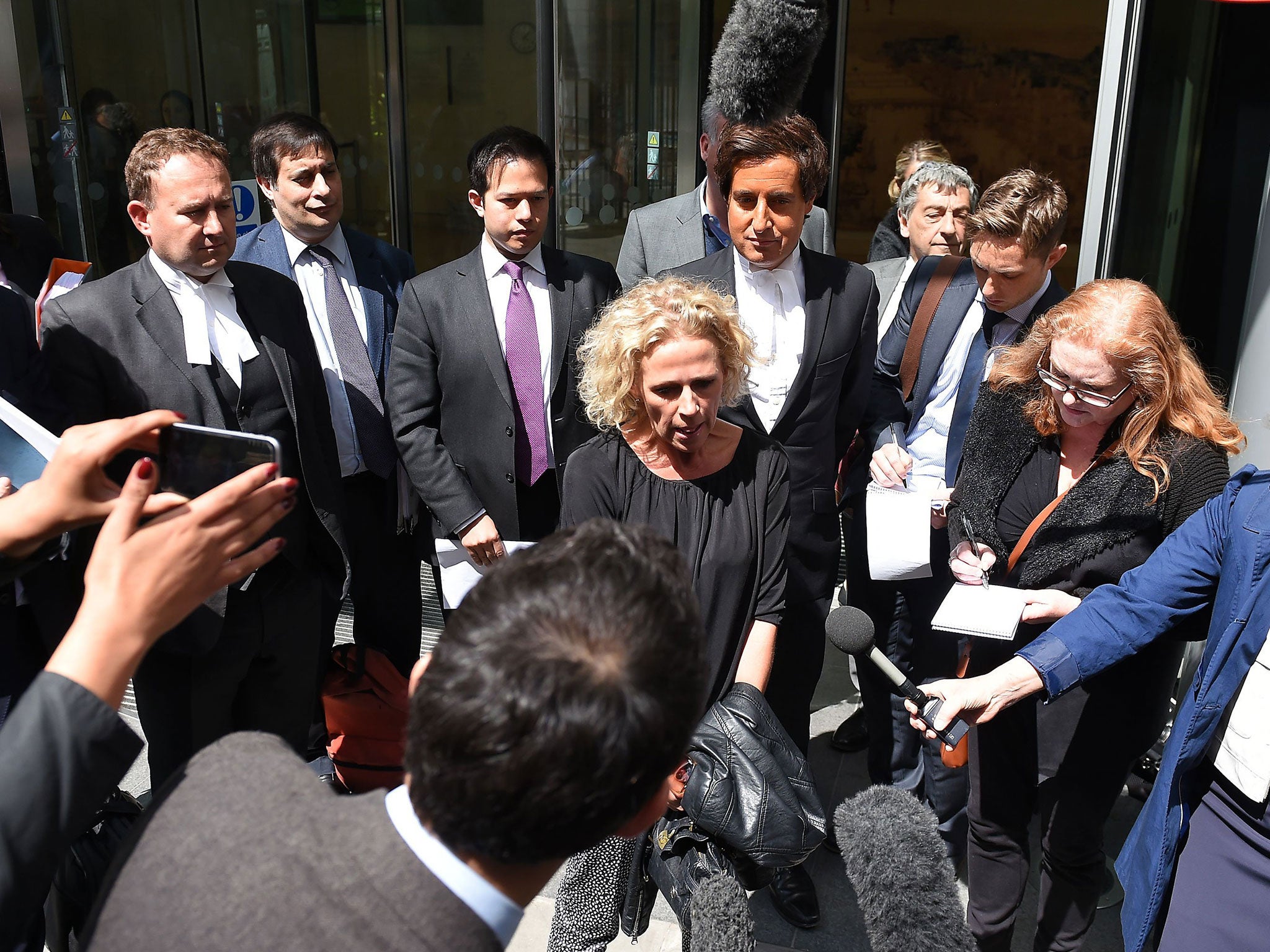 Actress Lucy Taggart, centre, speaks to the media outside the Rolls Building