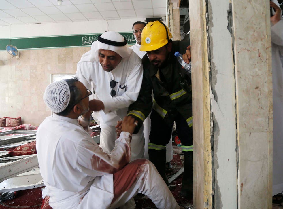 People help a man wounded in a suicide attack on the Shiite Imam Ali mosque