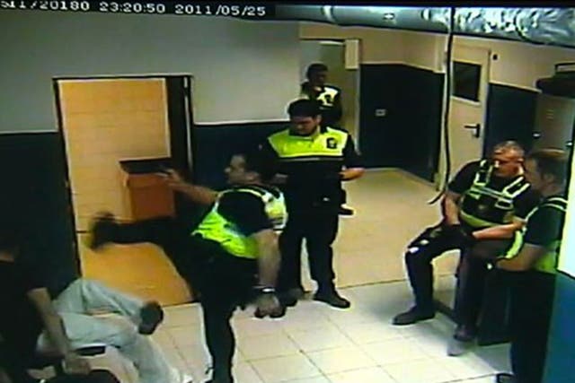 Policeman kicks handcuffed suspect 