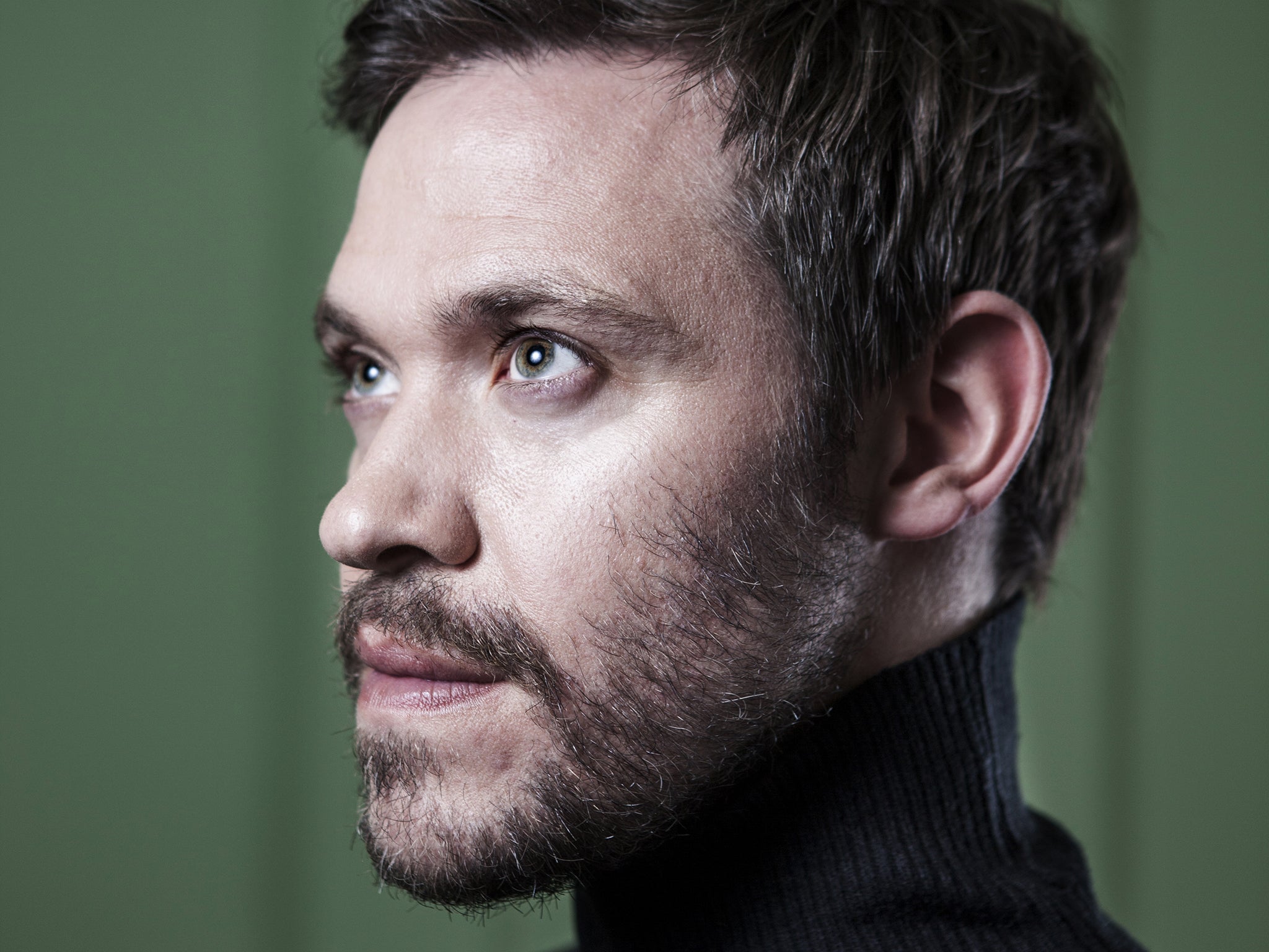 Will Young poses while sporting a beard and turtle neck in a Soho house