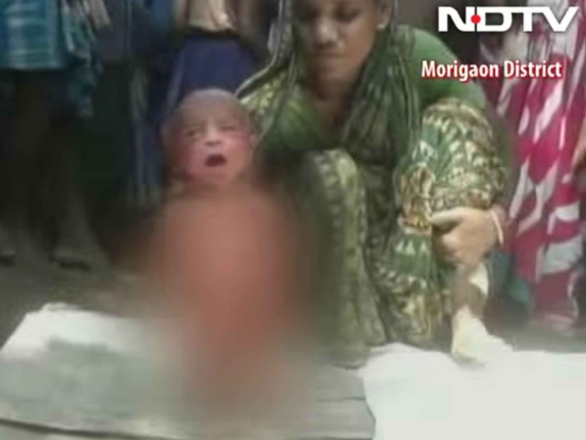 A woman forces a new born baby to walk