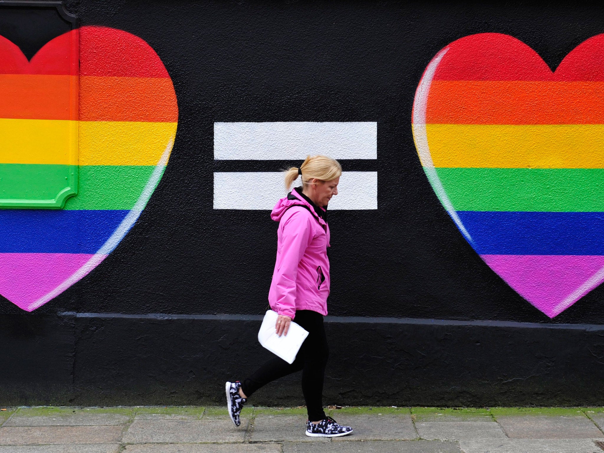 A woman walks past a mural in support of same-sex marriage in Dublin as polls opened yesterday