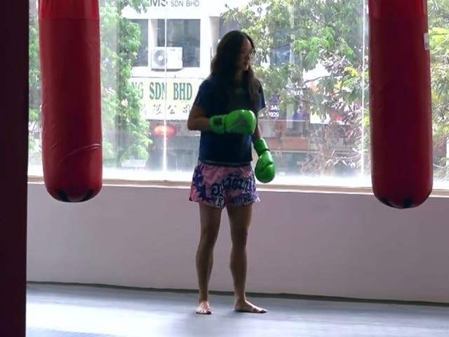The 'nerdy girl' sizes up a punch bag before challenging the coaches to a bout