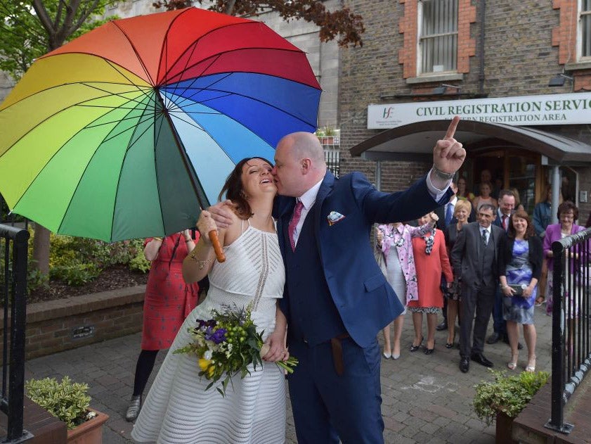 Newly married Anna and Vincent Fox share a kiss as they mark their support for a Yes vote in Dublin on polling day