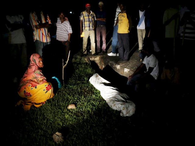 Relatives and friends gather around the covered body of Zedi Feruzi, the head of opposition party UPD, who was shot dead by gunmen 