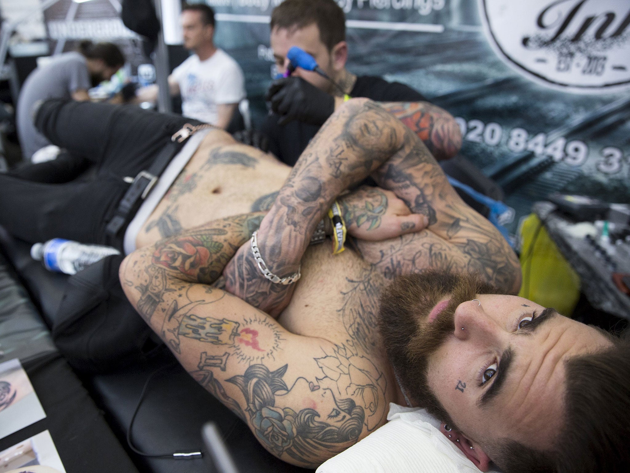 A man is tattooed during the Great British Tattoo Show in Alexandra Palace