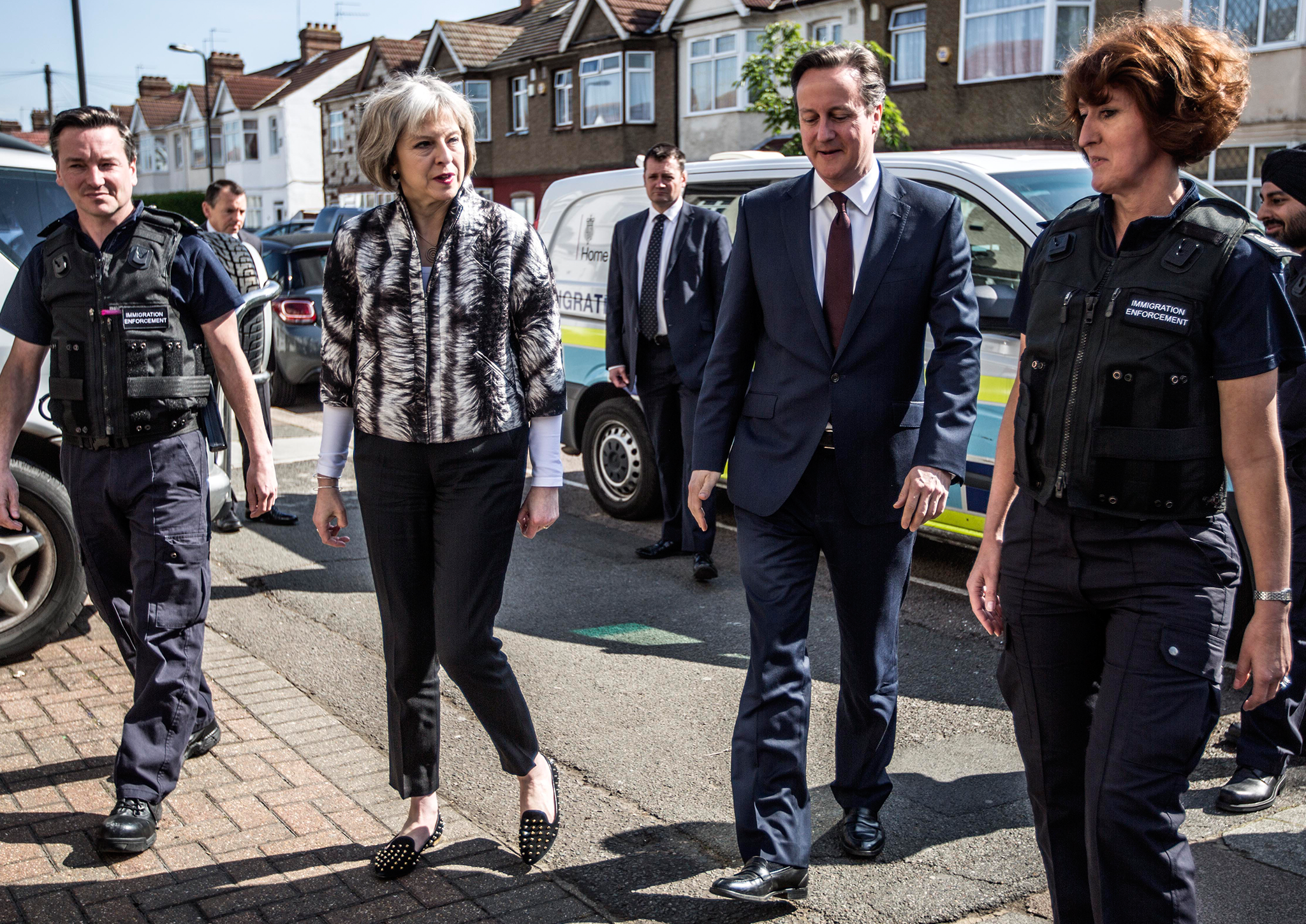 Theresa May and David Cameron talk to Immigration Enforcement officers after the officers raided residential properties looking for illegal immigrants