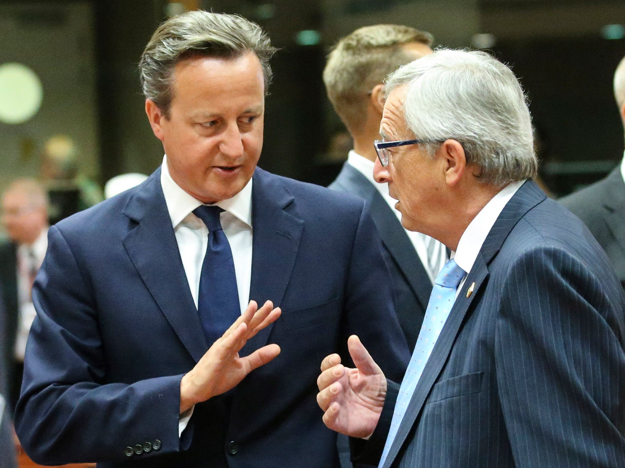 British Prime Minister David Cameron talks with President-elect of the European Commission Jean-Claude Juncker at the start of a Special Meeting of the European Council at EU Council headquarters in Brussels