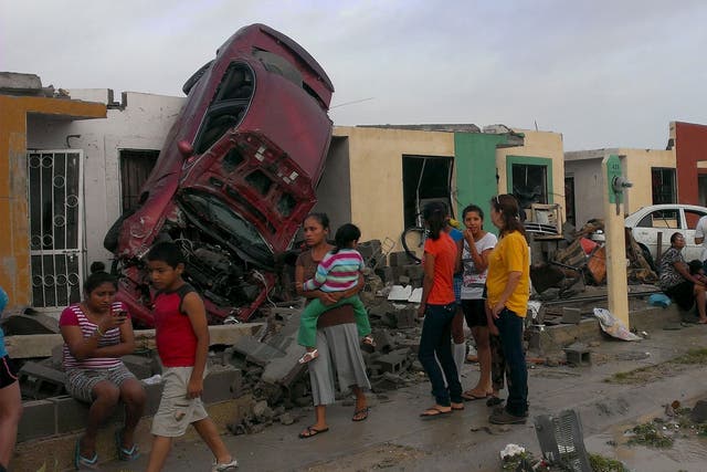 Residents of Ciudad Acuna stand by their homes after the tornado swept through the boder city