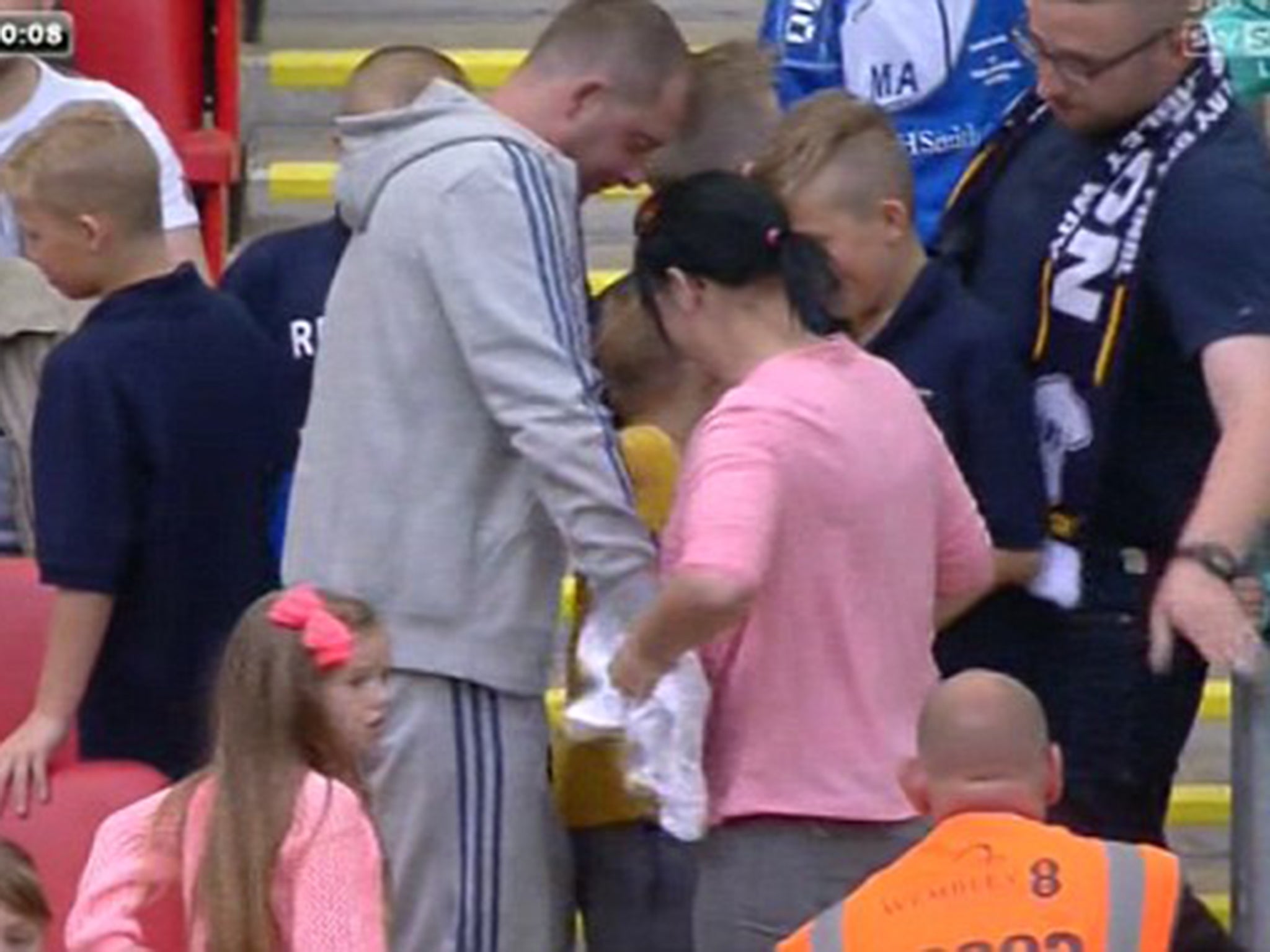A woman appears to snatch Jermaine Beckford's shirt away from an eight-year-old Preston fan