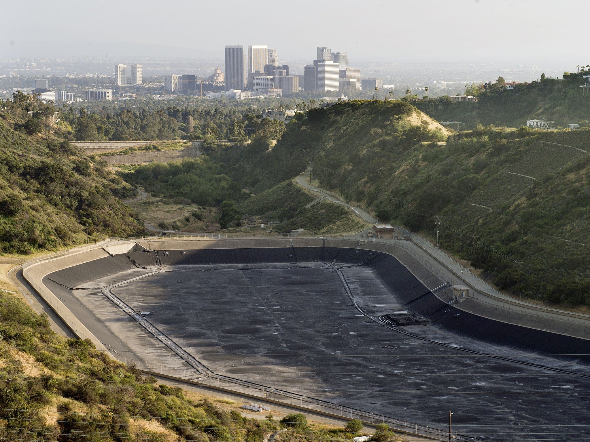 An empty water reservoir is seen in the hills above Los Angeles